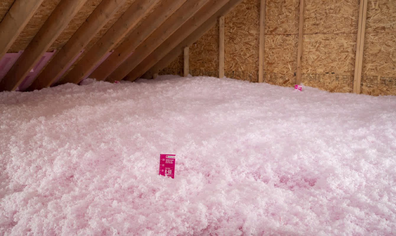 Attic with a fresh, even blanket of pink blown-in insulation